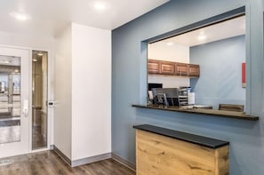 A modern kitchen with a large mirror, wooden cabinets, and a countertop. - Value Place Beaumont, TX (Beaumont)