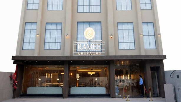 Um edifício de vários andares com uma placa indicando 'RAMEE Collection' no andar térreo.