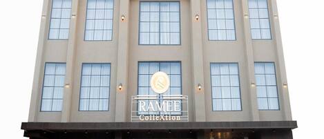 A multi-story building with a sign reading 'RAMEE Collection.'