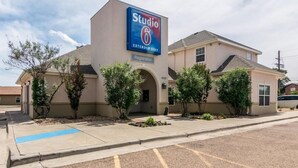 A Studio 6 Extended Stay hotel with a registration sign, a parking lot, and a clear sky. - Studio 6 Lubbock TX Medical Center (Lubbock)