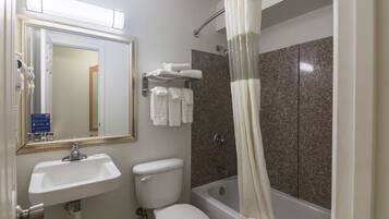 A bathroom with a sink, toilet, bathtub, and a shower curtain.
