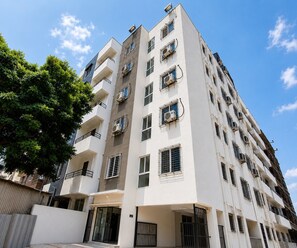 A multi-story residential building with balconies, air conditioning units, and a gated entrance. - Classic Phase-i Hinjewadi (Paud)