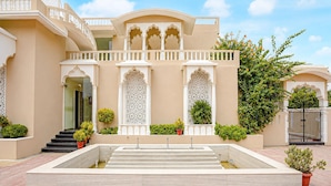 A building with a central courtyard, a staircase leading to the entrance, and a gated entrance. - Classic Amar Resorrt (Motihari)