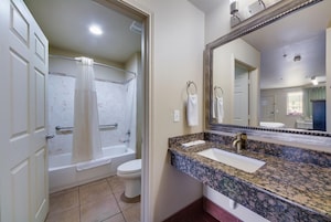 A bathroom with a bathtub, toilet, and sink.