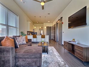A modern living room with a sofa, coffee table, and a TV mounted on the wall.