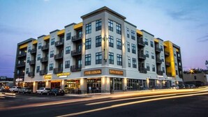 A multi-story hotel with a modern design, featuring balconies on each floor and a ground-level restaurant. - Two bedroom two bath, walk to UAB and dining (Birmingham)