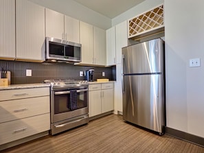 A modern kitchen with stainless steel appliances, including a microwave, oven, and refrigerator.