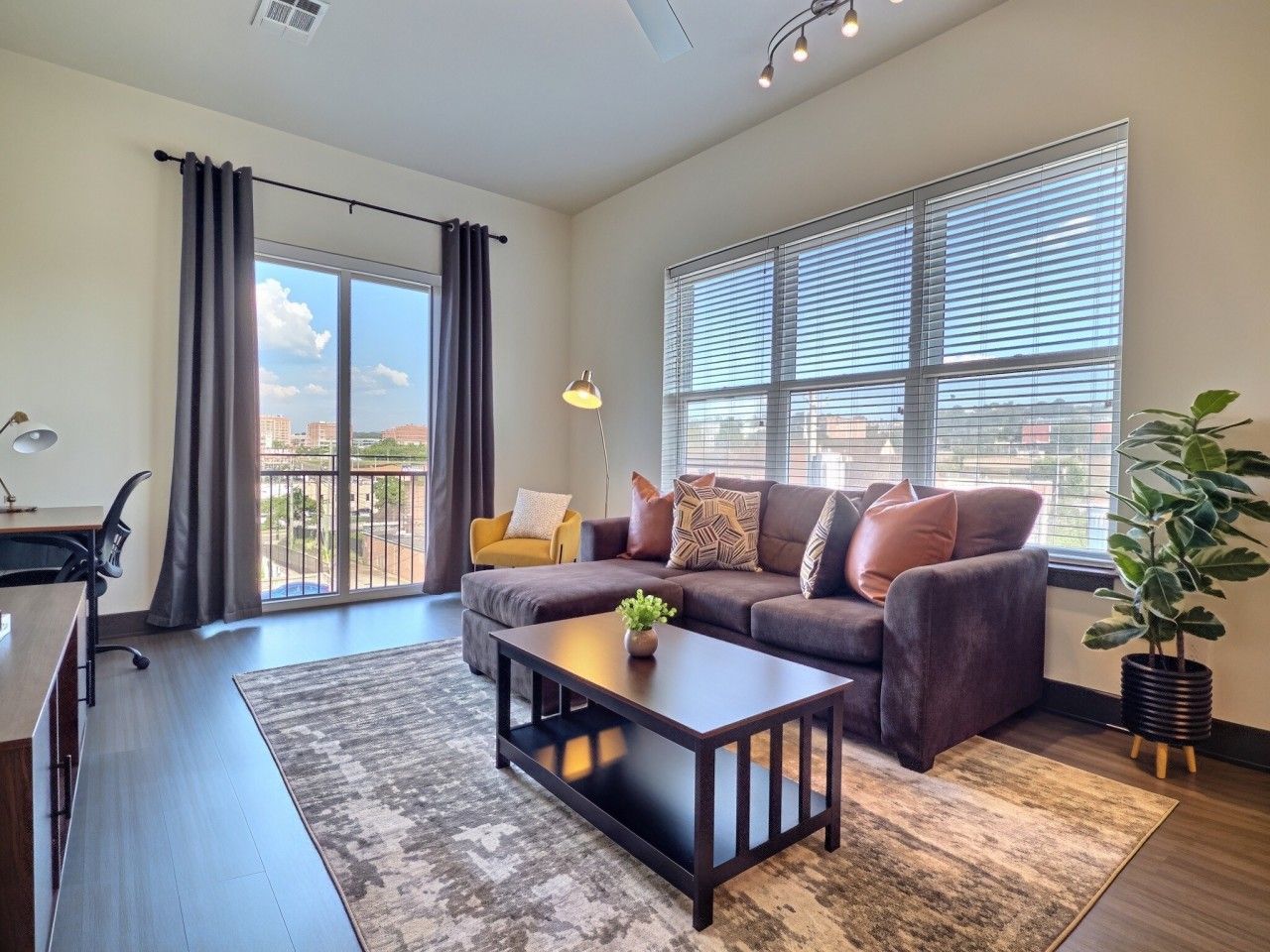 A modern living room with a sofa, coffee table, and a potted plant.