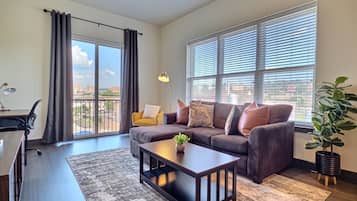 A modern living room with a sofa, coffee table, and a potted plant.