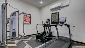 A gym with a treadmill, elliptical, and weight machine. - Two bedroom two bath, walk to UAB and dining (Birmingham)