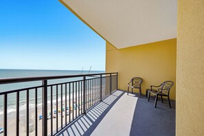 A balcony with a view of the beach and ocean, featuring a railing and two chairs. - Anderson 1103 - Oceanfront 2BR Condo (Myrtle Beach)