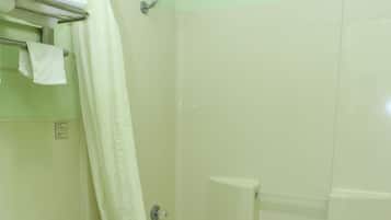 A bathroom with a toilet, a bathtub, and a shower area.