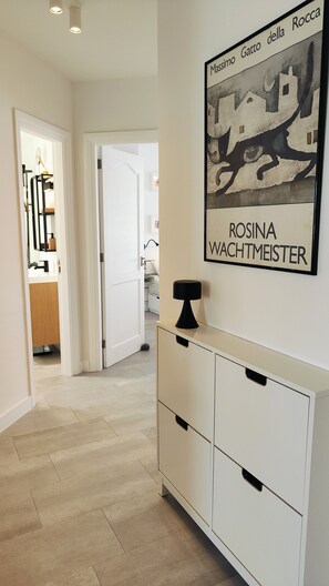 A hallway with a white cabinet and a framed artwork on the wall. - Arena Home, Chic, and Sea View. Next to the port of Corralejo (Corralejo)