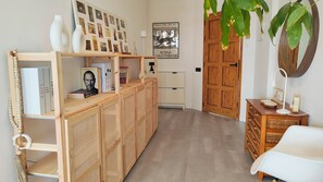 A hallway with a wooden bookshelf, a framed artwork, a door, and a plant. - Arena Home, Chic, and Sea View. Next to the port of Corralejo (Corralejo)