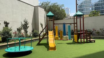 A playground with a slide, swings, and a climbing structure.