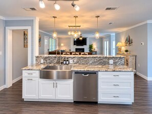 A modern kitchen with a central island, stainless steel appliances, and pendant lighting.