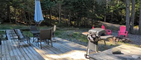 Une terrasse extérieure équipée d’un barbecue, de chaises et d’une table.