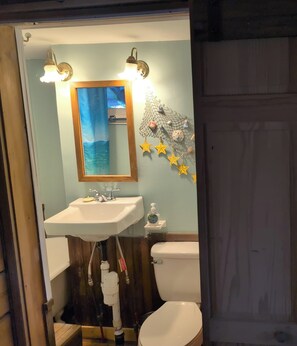 A bathroom with a white sink, a mirror, and a toilet.