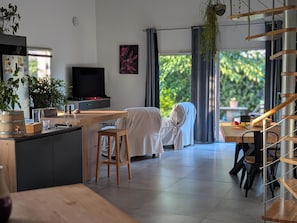 Eine moderne Küche mit Flachbildfernseher, Holztheke und Essbereich mit Tisch und Stühlen.