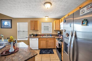 Una cocina con armarios de madera, un refrigerador de acero inoxidable y un lavavajillas.
