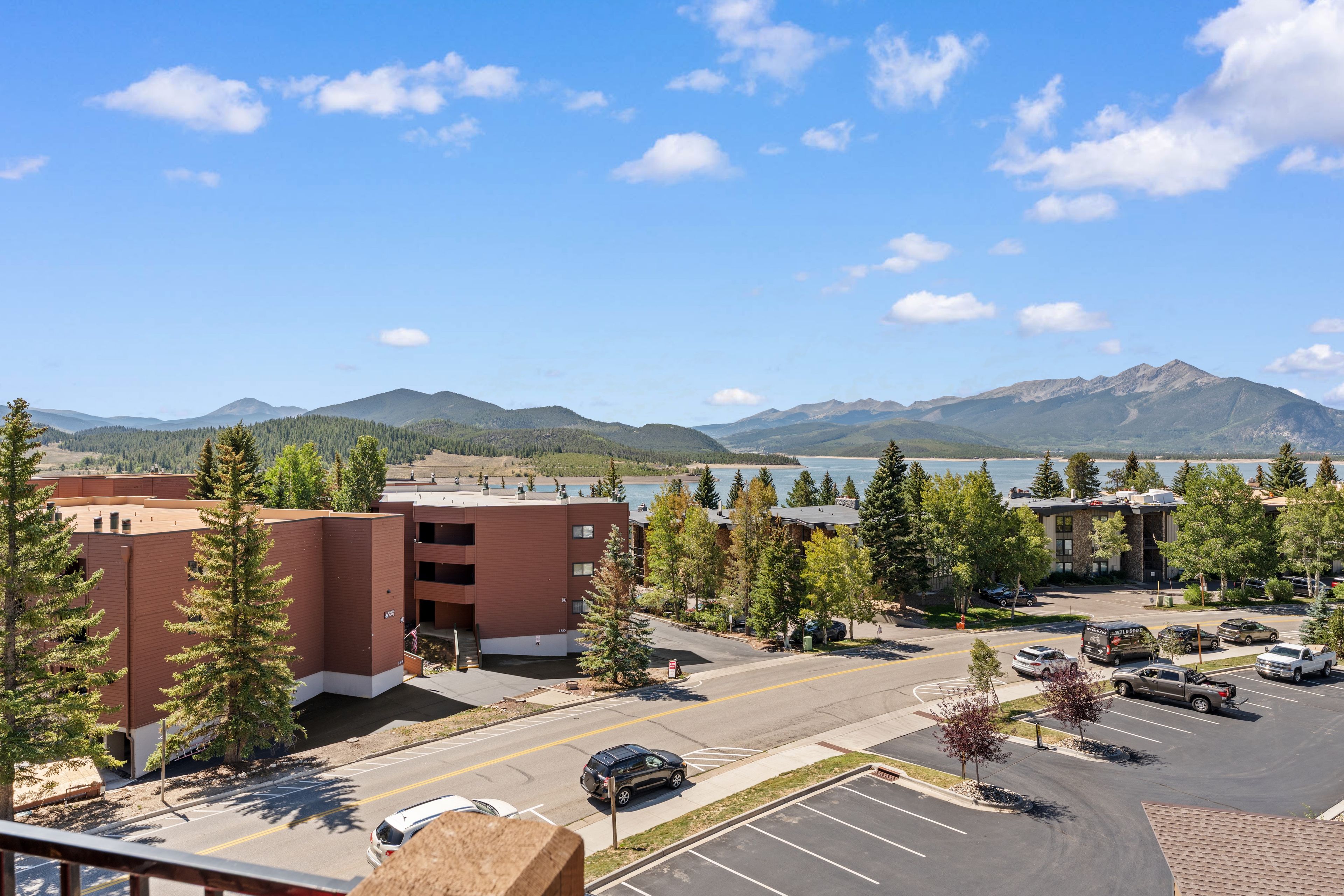 A parking lot with a view of mountains and a lake.