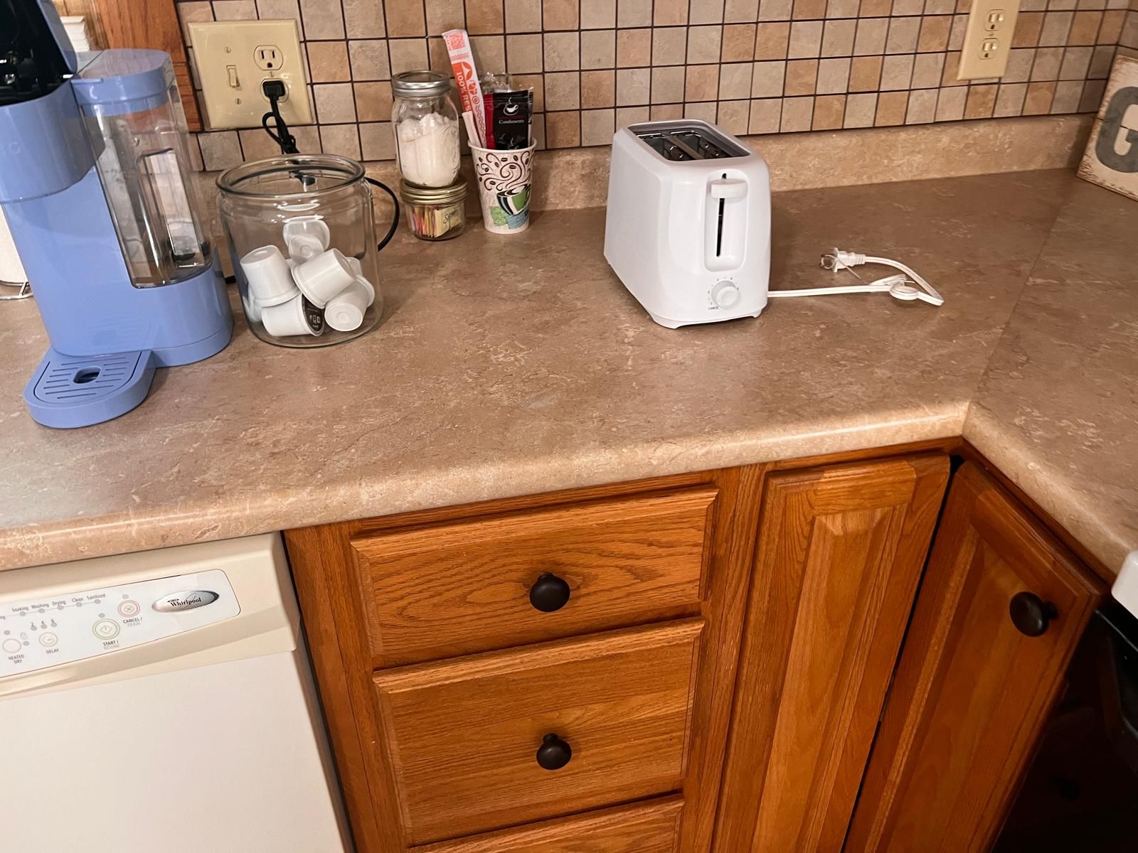 A kitchen counter with a coffee maker, a toaster, and various kitchen items.