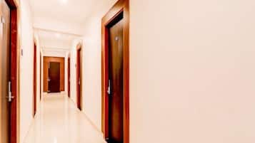 A long, narrow hotel corridor with doors on both sides.