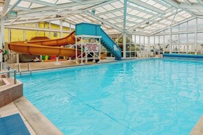 Ein Hallenbad mit Wasserrutsche und Rettungsschwimmerstation.