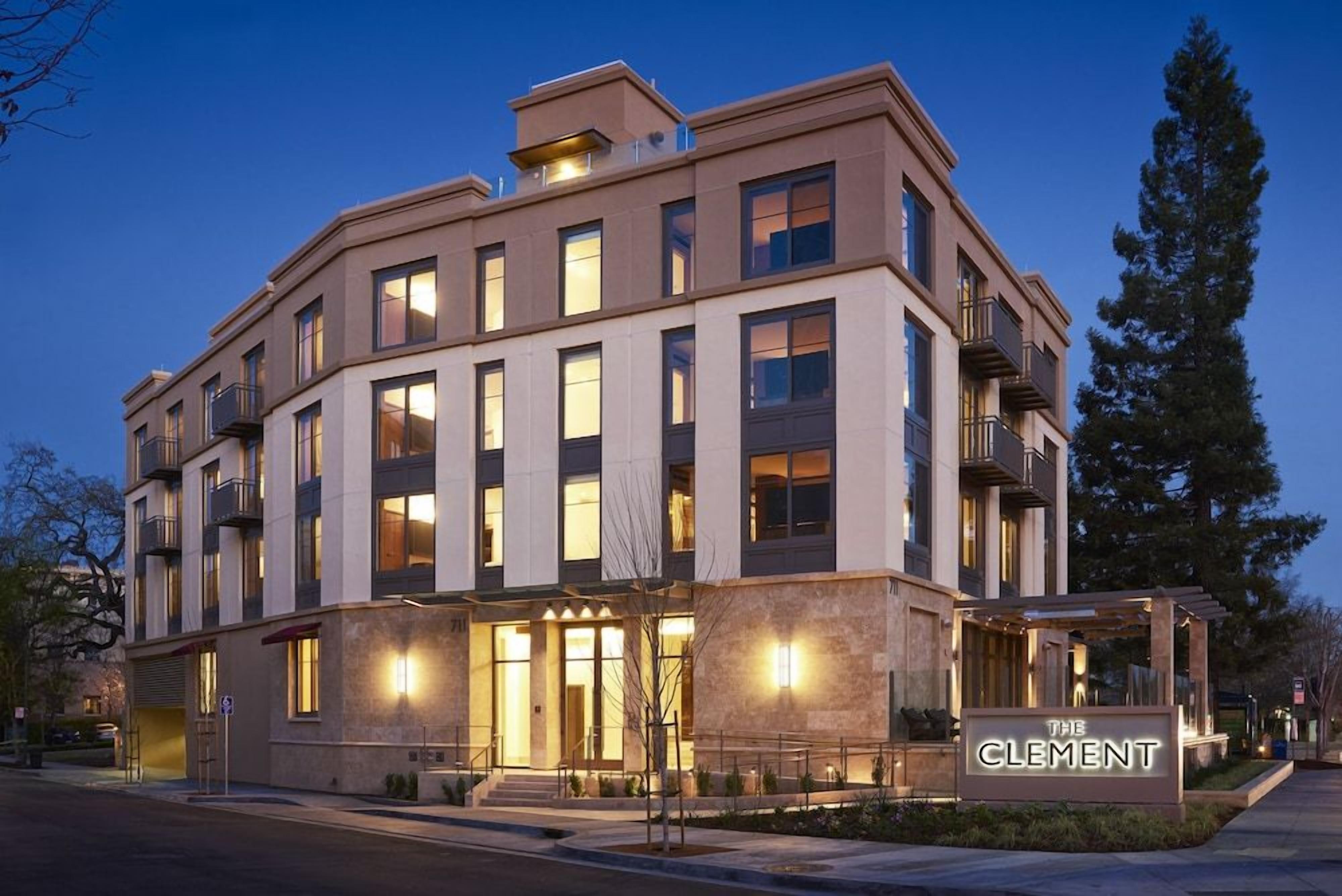 A multi-story hotel with a prominent entrance, balconies, and a sign indicating the name 'The Clement.'