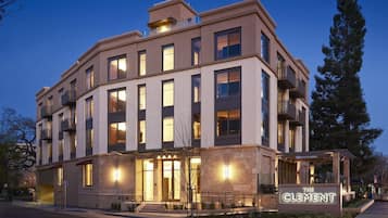 A multi-story hotel with a prominent entrance, balconies, and a sign indicating the name 'The Clement.'