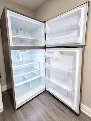 Un refrigerador moderno de acero inoxidable con varios compartimentos y dispensador de agua.