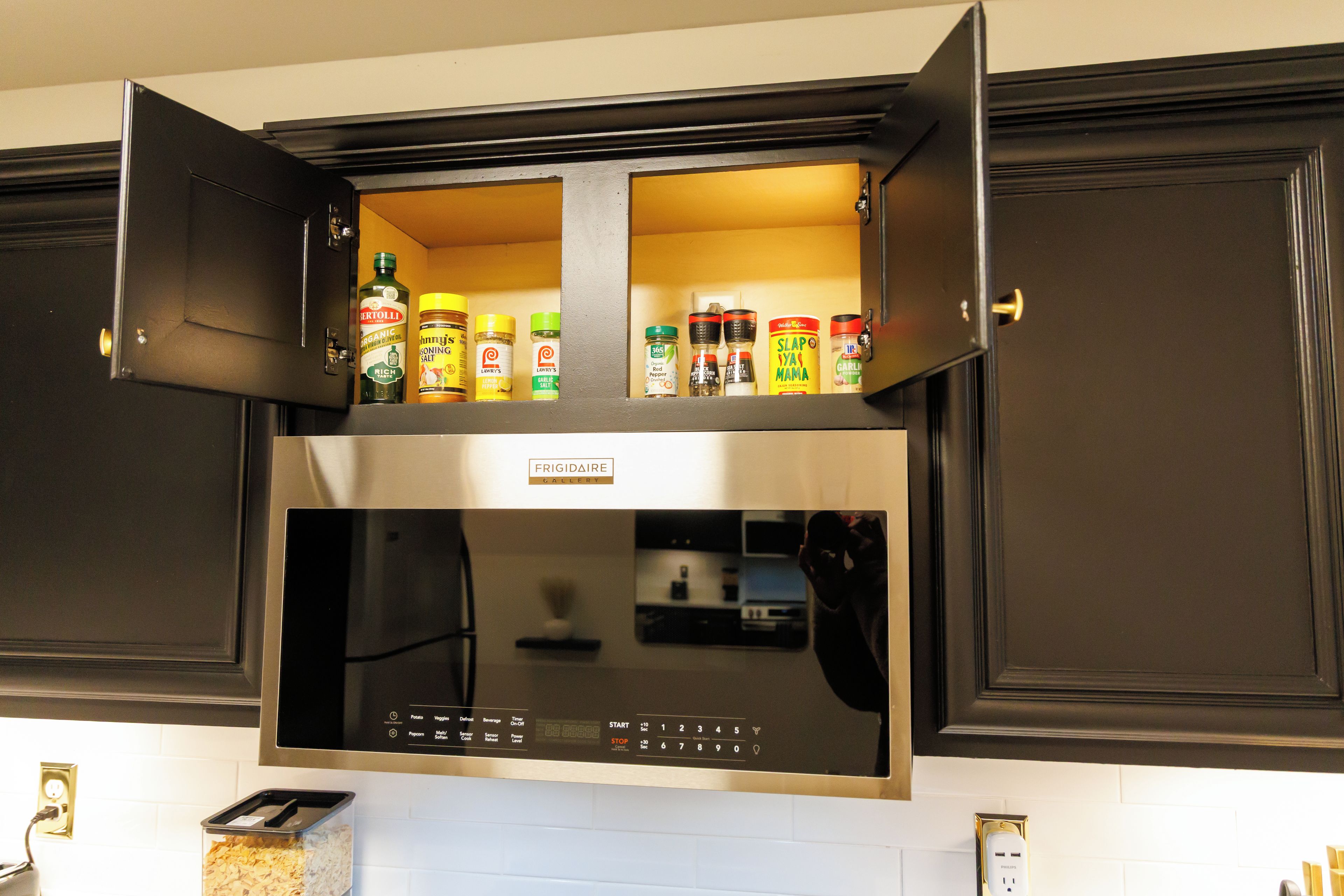 Uma cozinha com micro-ondas embutido e um porta-temperos acima.