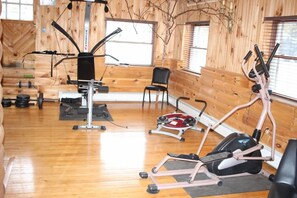 Une salle de sport équipée de matériel d’exercice, avec une chaise et une fenêtre.