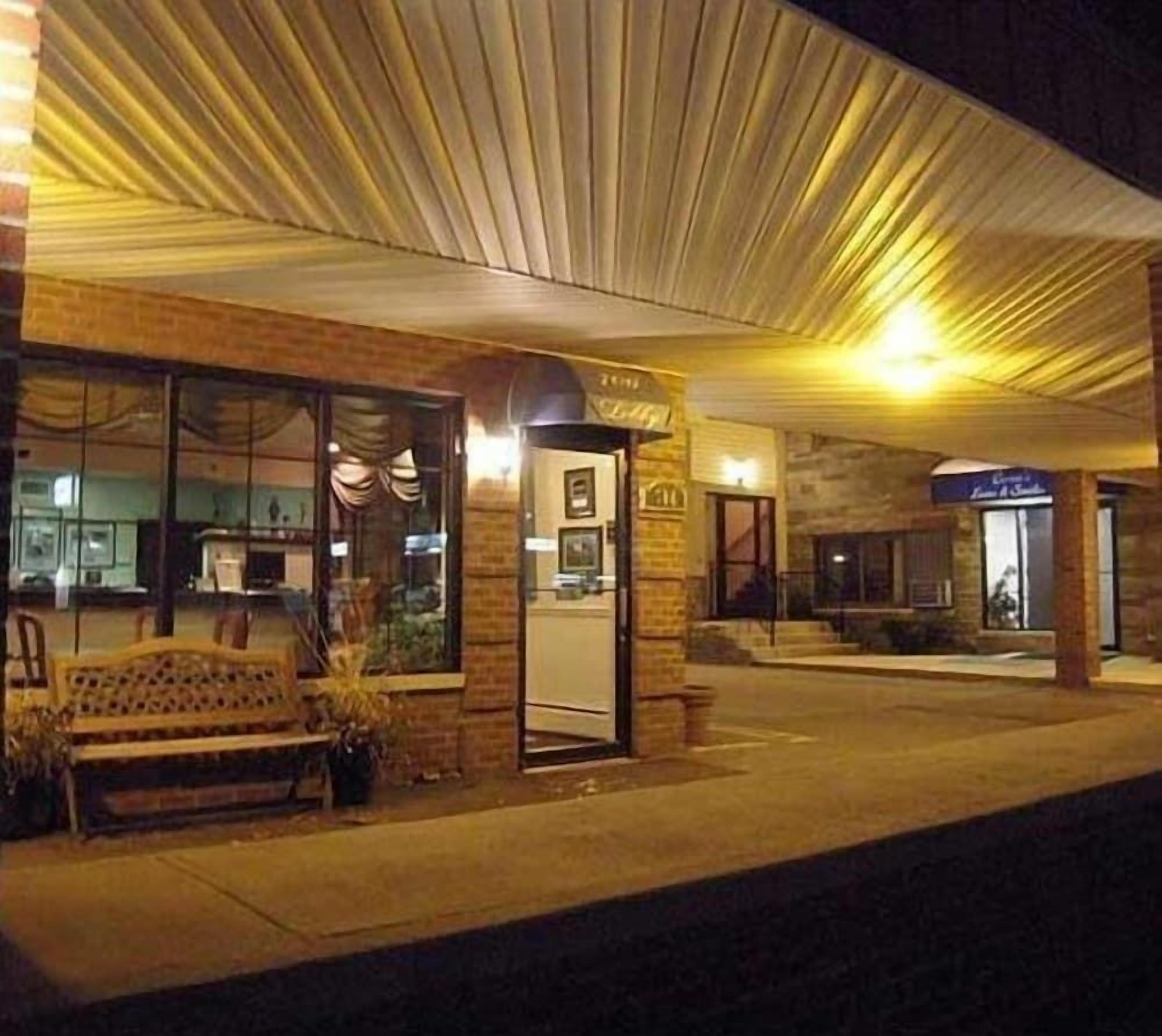 A building with a brick facade, a glass entrance, and a bench outside.