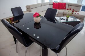 Ein Essbereich mit einem schwarzen Tisch, vier Stühlen und einer Blumenvase.