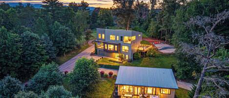 A modern two-story house with a large deck and a separate garage.