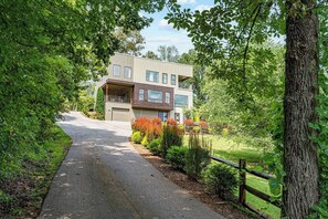 A modern two-story house with a covered driveway and a fenced garden. - Sleeps 26 | Pickleball+Game Room+Theater+Sauna (Leicester)