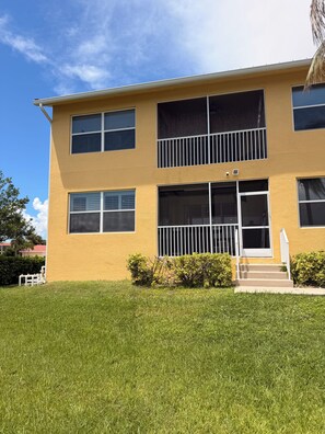 A two-story building with a flat roof, large windows, and a small front porch. - Snowbird Waterfront Retreat 3BR, Private 40' Dock, Heated Pool & Garage Like New (Punta Gorda)