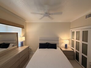 A bedroom with a bed, nightstands, a dresser, a ceiling fan, and a wardrobe. - Snowbird Waterfront Retreat 3BR, Private 40' Dock, Heated Pool & Garage Like New (Punta Gorda)