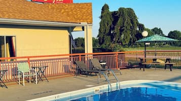 Un espace piscine avec des chaises longues et un panneau indiquant « Stay Inn ».