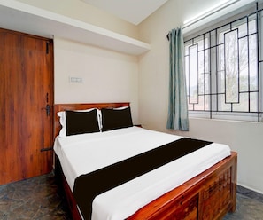 A bedroom with a wooden bed, a window with metal bars, and a door.