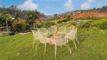 Een gazon met witte, metalen stoelen voor bezoekers.
