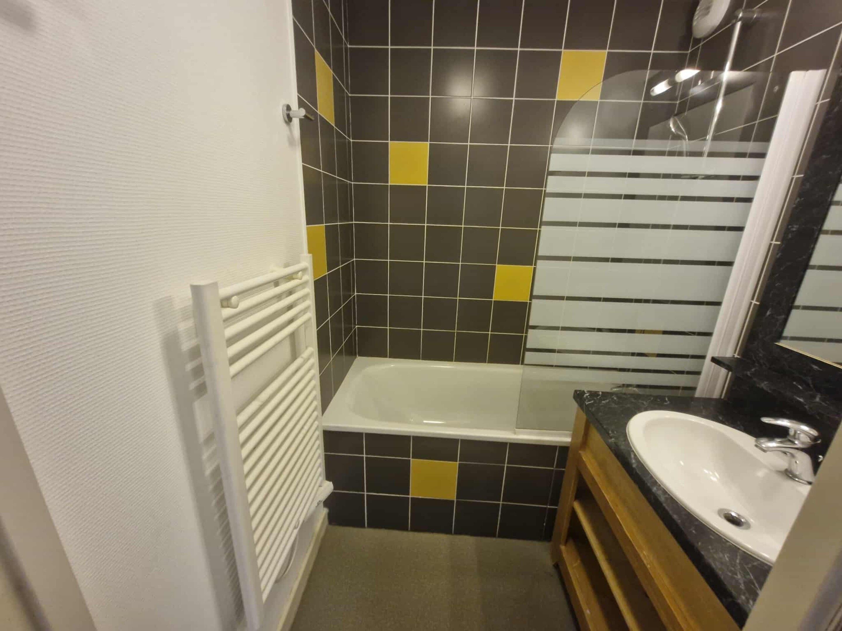Een badkamer met een bad, een wastafel en een douche.