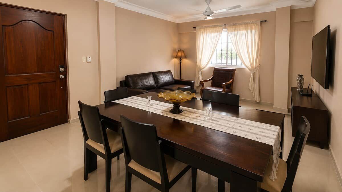 Un comedor con una mesa de madera, sillas, un sofá y un televisor.