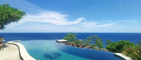 A infinity pool with a clear view of the ocean.