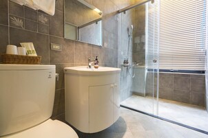 Un baño moderno con inodoro, lavamanos y ducha.