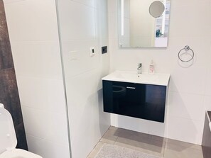 A bathroom with a white sink, a mirror above it, and a towel ring on the wall. - Sunny Apartment in La Zenia for 4 (Orihuela)