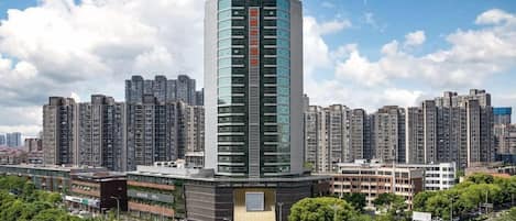 Ein hoch aufragendes Hotel mit modernem Design, umgeben von weiteren Wolkenkratzern.