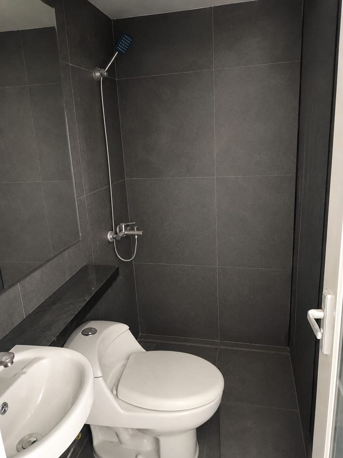 A bathroom with a toilet, sink, and shower.