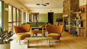 Una sala de estar moderna con un sofá, dos sillones, una mesa de centro y una chimenea.